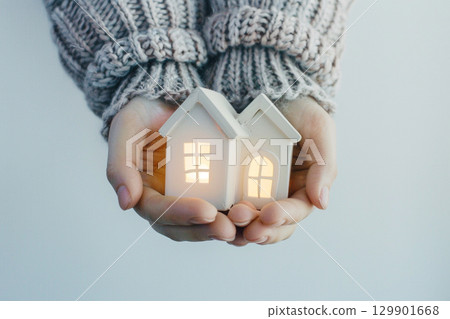 An image of a small house and warmth that can be held in the palm of your hand 129901668