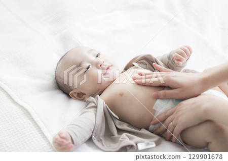 年輕的母親照顧她的孩子 年輕的母親照顧她的孩子 129901678
