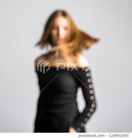 Abstract blurred woman silhouette in white studio background Abstract blurred woman silhouette in white studio background 129902085