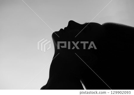 Woman black face silhouette with flying hairs Woman black face silhouette with flying hairs 129902093