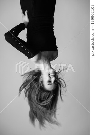 Woman hanging upside down portrait Woman hanging upside down portrait 129902102