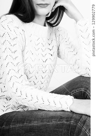 Woman with jeans and sweater studio portrait 129902779