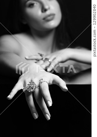 Studio portrait of beautiful and sexy woman with fancy make-up and various rings on her fingers Studio portrait of beautiful and sexy woman with fancy make-up and various rings on her fingers 129902840