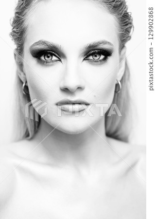Beautiful woman with smokey makeup close up studio portrait 129902868