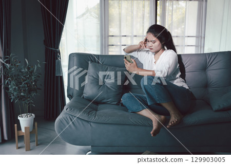 Sorrowful woman sat alone, overwhelmed by emotion, her sad and unhappy expression revealing deep despair, stress and distress left feeling depressed. sorrowful sad, despair alone, depressed stress 129903005