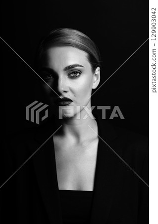 Beautiful woman with classic hairstyle and black suit close-up studio portrait Beautiful woman with classic hairstyle and black suit close-up studio portrait 129903042