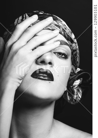 Woman with scarf on her head black and white studio portrait 129903101