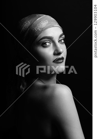 Woman with scarf on her head black and white studio portrait Woman with scarf on her head black and white studio portrait 129903104