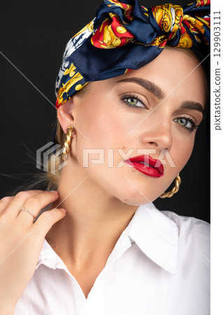 Woman with make-up and scarf on her head studio portrait Woman with make-up and scarf on her head studio portrait 129903111