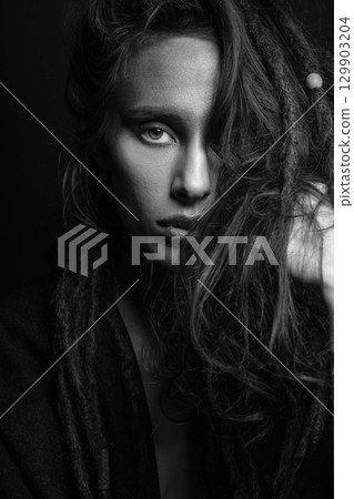 Studio portrait of woman with make-up and hair with dreadlocks 129903204