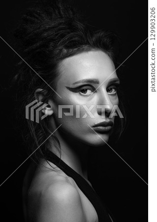 Studio portrait of beautiful woman with eye shadows and dreadlocks 129903206