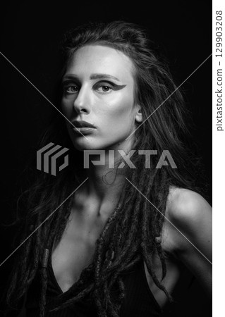 Studio portrait of beautiful woman with eye shadows and dreadlocks in RGB color split effect style 129903208