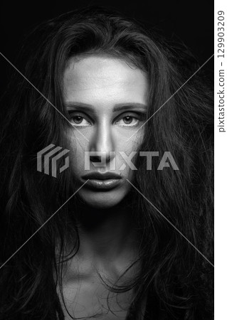 Studio portrait of beautiful woman with eye shadows and dreadlocks Studio portrait of beautiful woman with eye shadows and dreadlocks 129903209