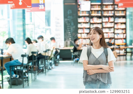 Young woman looking for a book in the library 129903251