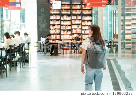 尋找一本書在圖書館裡的年輕女子 129903252