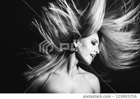 Beautiful woman with flying hair studio portrait 129903356