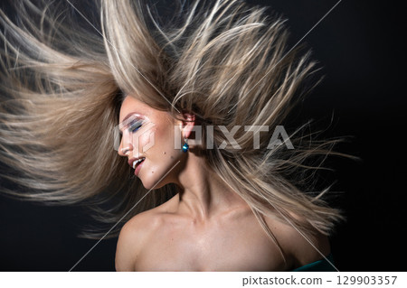 Beautiful woman with flying hair studio portrait 129903357