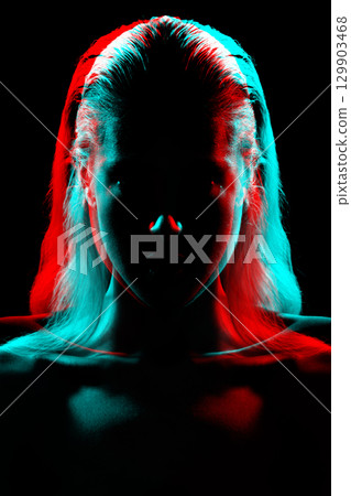 Studio portrait of woman silhouette partly illuminated with light in RGB color split effect style 129903468