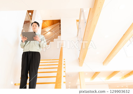 Construction worker inspecting the interior of a house 129903632