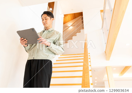 Construction worker inspecting the interior of a house 129903634