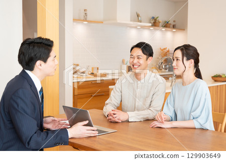 一位商人和一對年輕夫婦在客廳討論生意 129903649