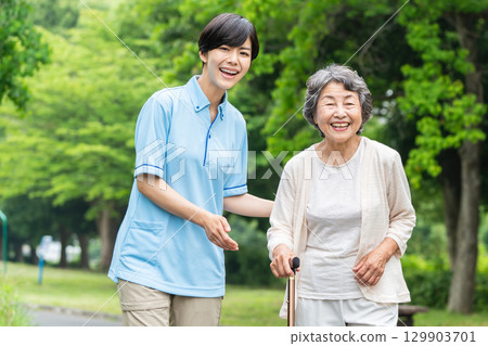 Senior woman and caregiver taking a walk 129903701