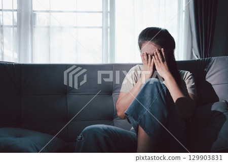 Depression woman sit on sofa. Despair sorrow person sitting alone and hugging knees, Boring sad upset frustrated stressed. struggling to find hope amid suffocating burden. mental health concept. 129903831