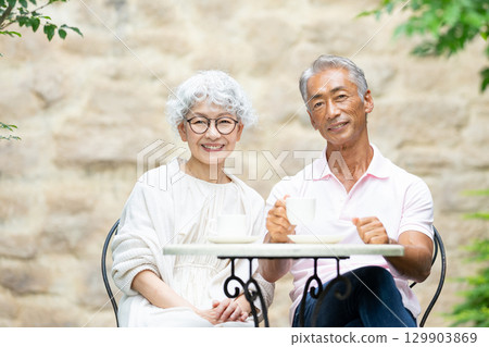 Senior couple sitting on a bench drinking tea Senior couple sitting on a bench drinking tea 129903869