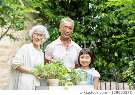 Senior couple and child gardening 129903878