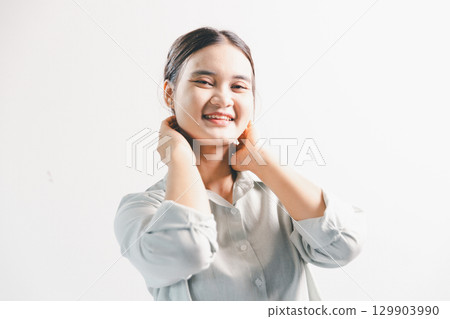 Asian woman rejoicing, looking happy, champion, fist pump gesture, standing over white background. young woman had happy, positive expression on her face, highlighted by bright smile. Asian woman rejoicing, looking happy, champion, fist pump gesture, standing over white background. young woman had happy, positive expression on her face, highlighted by bright smile. 129903990