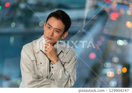一名身穿工作服、雙臂交叉思考的男子 129904247