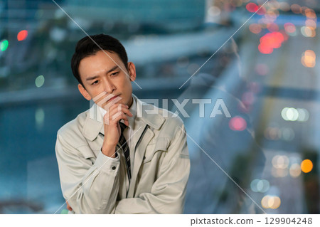 一名身穿工作服、雙臂交叉思考的男子 129904248