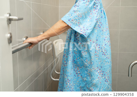 Asian elderly woman patient use toilet bathroom handle security in nursing hospital, healthy strong medical concept. Asian elderly woman patient use toilet bathroom handle security in nursing hospital, healthy strong medical concept. 129904358