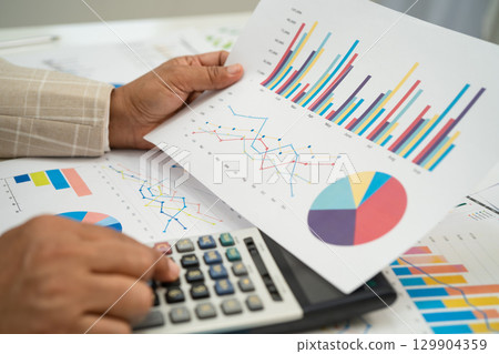 Asian business woman working with financial graph. 129904359