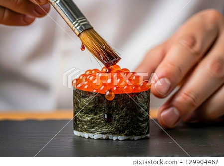 The moment soy sauce is applied to fresh salmon roe gunkanmaki 129904462