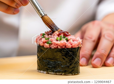 壽司師傅在軍艦上塗抹醬油的照片 壽司師傅在軍艦上塗抹醬油的照片 129904467