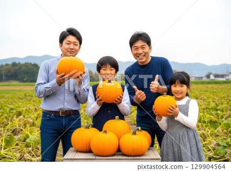 Family photo of harvesting pumpkins on a farm in autumn Family photo of harvesting pumpkins on a farm in autumn 129904564