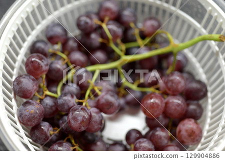 Fresh Purple Grapes in white Colander Fresh Purple Grapes in white Colander 129904886