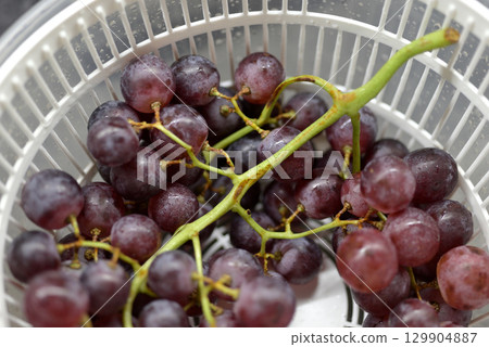 Fresh Purple Grapes in white Colander Fresh Purple Grapes in white Colander 129904887