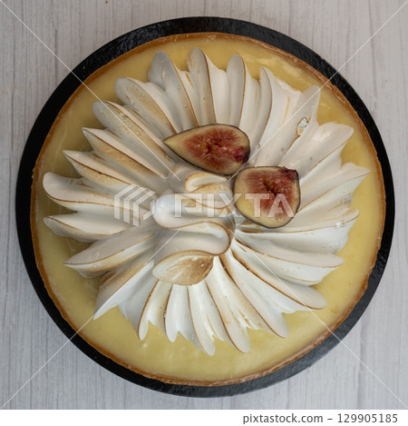 Sunny and Bright Orange Lemon Citrus Meringue Pie on a black plate on white background 129905185