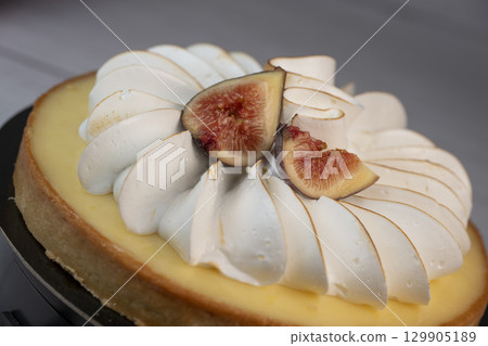 Sunny and Bright Orange Lemon Citrus Meringue Pie on a black plate on white background 129905189