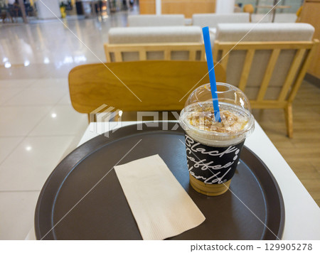 Refreshing Iced Coffee Beverage Served on a Tray in a Cafe Setting 129905278
