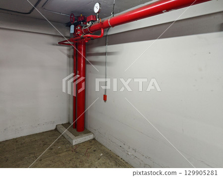 Red Fire Pump System in Empty Basement Industrial Space 129905281