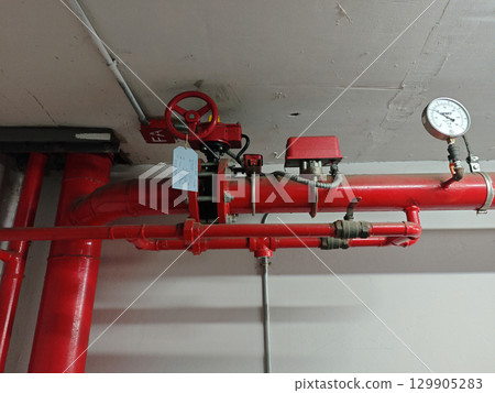 Red Pipes and Valves in Industrial Space with Pressure Gauge Detail Red Pipes and Valves in Industrial Space with Pressure Gauge Detail 129905283