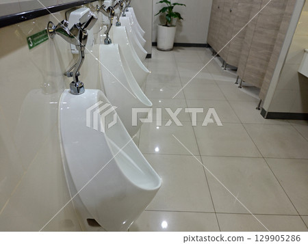 Modern and Clean Male Restroom with White Urinals and Tiles 129905286