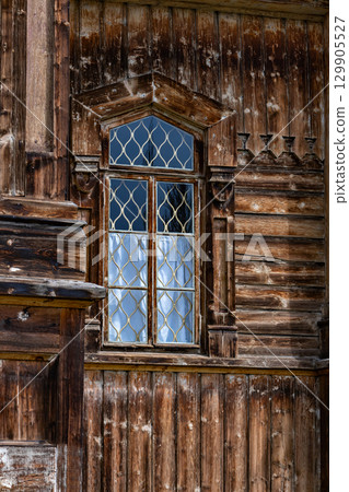 Wooden window with metal bars in old wooden house.  129905527