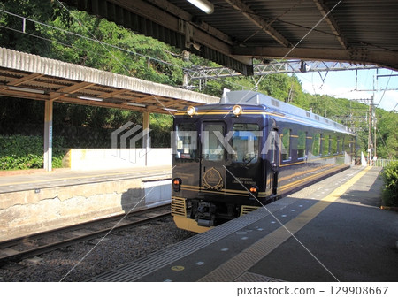 旅遊特快列車「藍色交響曲號」駛入奈良縣近鐵吉野線無人車站大田站。 旅遊特快列車「藍色交響曲號」駛入奈良縣近鐵吉野線無人車站大田站。 129908667