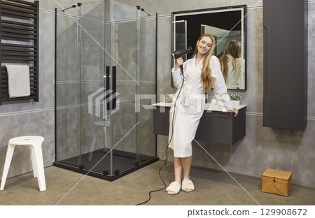 Positive Woman Drying Hair With Dryer In Bathroom 129908672