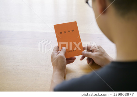 一名男子正在看他的退休金簿 129908977