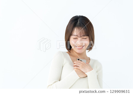 Young woman, casual, holding smartphone 129909631